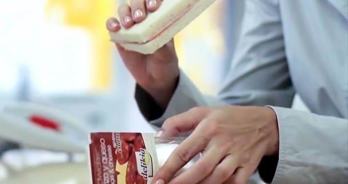 Imagen de persona con un sandwich en la mano